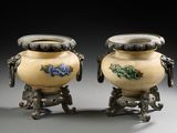 une paire de vases ornés d'anses en forme de dragon, posés sur des socles, sur fond gris