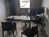 un bureau avec deux ordinateurs et une chaise dans une pièce