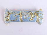 une photo d'une broche bleue et dorée ornée de personnages
