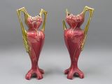 une paire de vases rouges et dorés posés sur une surface grise