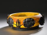 un gros plan d'un bracelet jaune et noir orné de feuilles