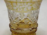 a yellow glass vase sitting on top of a white table