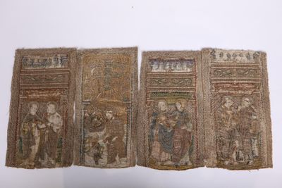 quatre morceaux de tissu sur lesquels sont représentés des personnages et des animaux