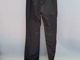 black pants hanging on a hanger against a wall in a room
