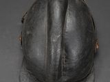 an old helmet is sitting on top of a gray surface