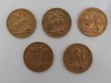 quatre types différents de pièces d'or sur une surface blanche