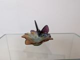 une petite table en verre sur laquelle est posé un petit oiseau