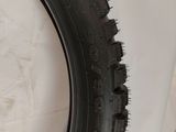 a close up of a tire on the side of a white wall