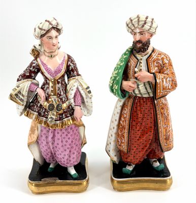 pair of figurines of a man and a woman dressed in traditional clothing