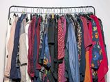 a lot of clothes hanging on a rack in a room
