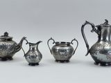 four pieces of silverware are arranged on a white surface