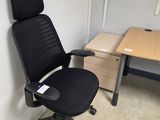 a black office chair sitting in front of a desk