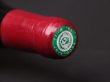 a close up of a red wine bottle with a green label
