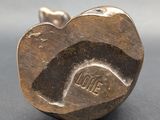 a close up of a metal apple shaped object on a table