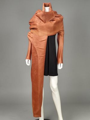 a mannequin wearing a brown coat and black dress on a mannequin mannequin