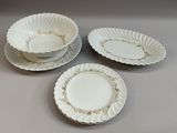 trois assiettes blanches bordées d'or sur un fond gris