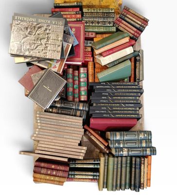 une boîte remplie de vieux livres posée sur une surface blanche
