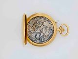 a close up of a pocket watch on a white surface
