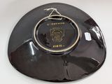 a black plate with a gold rim on a white table