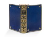 un vieux livre avec une couverture bleue et des bordures dorées