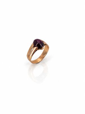 a close up of a gold ring with a purple stone
