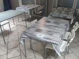 tables and chairs in a room with tile flooring and a window