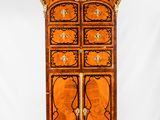une vieille commode en bois comportant de nombreux tiroirs et ornée de sculptures