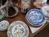une table sur laquelle sont disposées de nombreuses assiettes et figurines