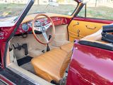 a red car with a tan leather seat and steering wheel