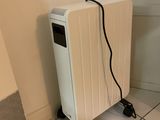 un radiateur blanc posé à même le sol, près d'un mur