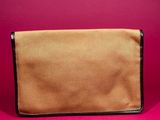 a brown and black purse sitting on top of a pink surface