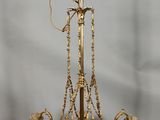 a gold chandelier hanging from the ceiling in a room
