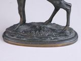 bronze statue of a deer on a base on a white surface