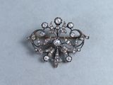un gros plan d'une broche en argent sertie de diamants