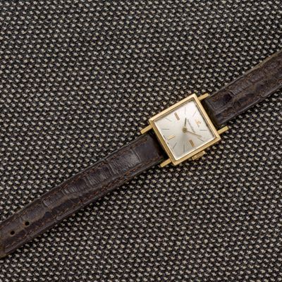 un gros plan d'une montre montée sur un bracelet en cuir marron