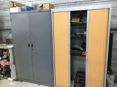une armoire métallique à deux portes, ouverte dans un garage