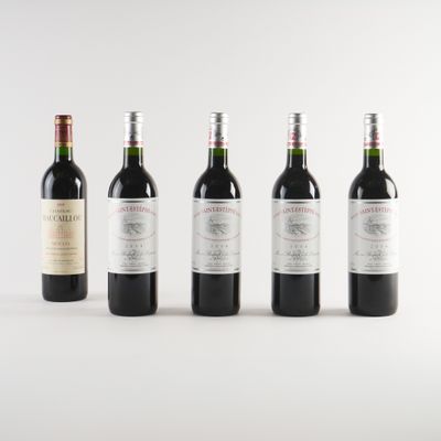 quatre bouteilles de vin sont alignées sur une surface blanche