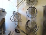 many pots and pans hanging on a rack in the kitchen
