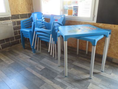 several blue chairs and a table in a room with a window