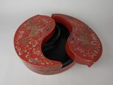 une boîte rouge dont le couvercle est orné d'un motif