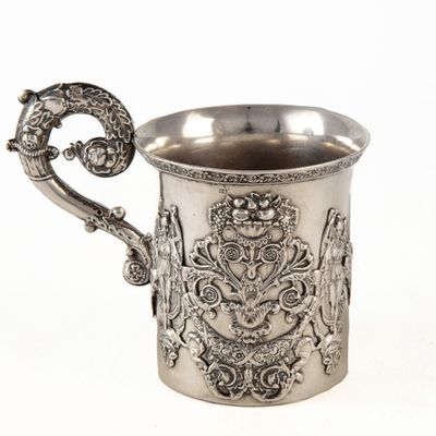 une coupe ancienne en argent avec une anse, sur fond blanc
