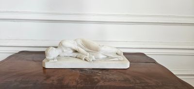 statue en marbre représentant un chien posé sur une table dans une pièce