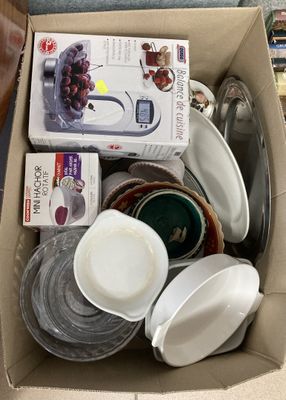 une boîte en carton remplie d'assiettes et de bols de toutes sortes