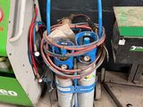 une image représentant un chariot bleu avec plusieurs bidons d'essence