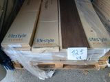 Plusieurs caisses en bois sont empilées sur une palette, accompagnées d'une étiquette de prix