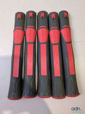 six tournevis noirs et rouges sont alignés sur une table