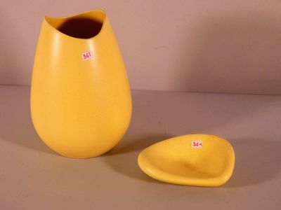 a yellow vase and a yellow plate on a table