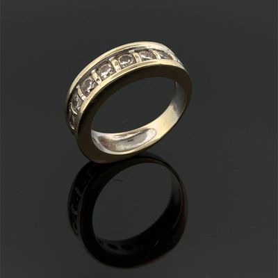 gros plan d'une bague en or avec des diamants sur une surface noire