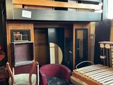 une pièce avec un lit, une chaise, un bureau et une mezzanine