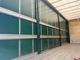 an image of a green garage door with a skateboard in the foreground